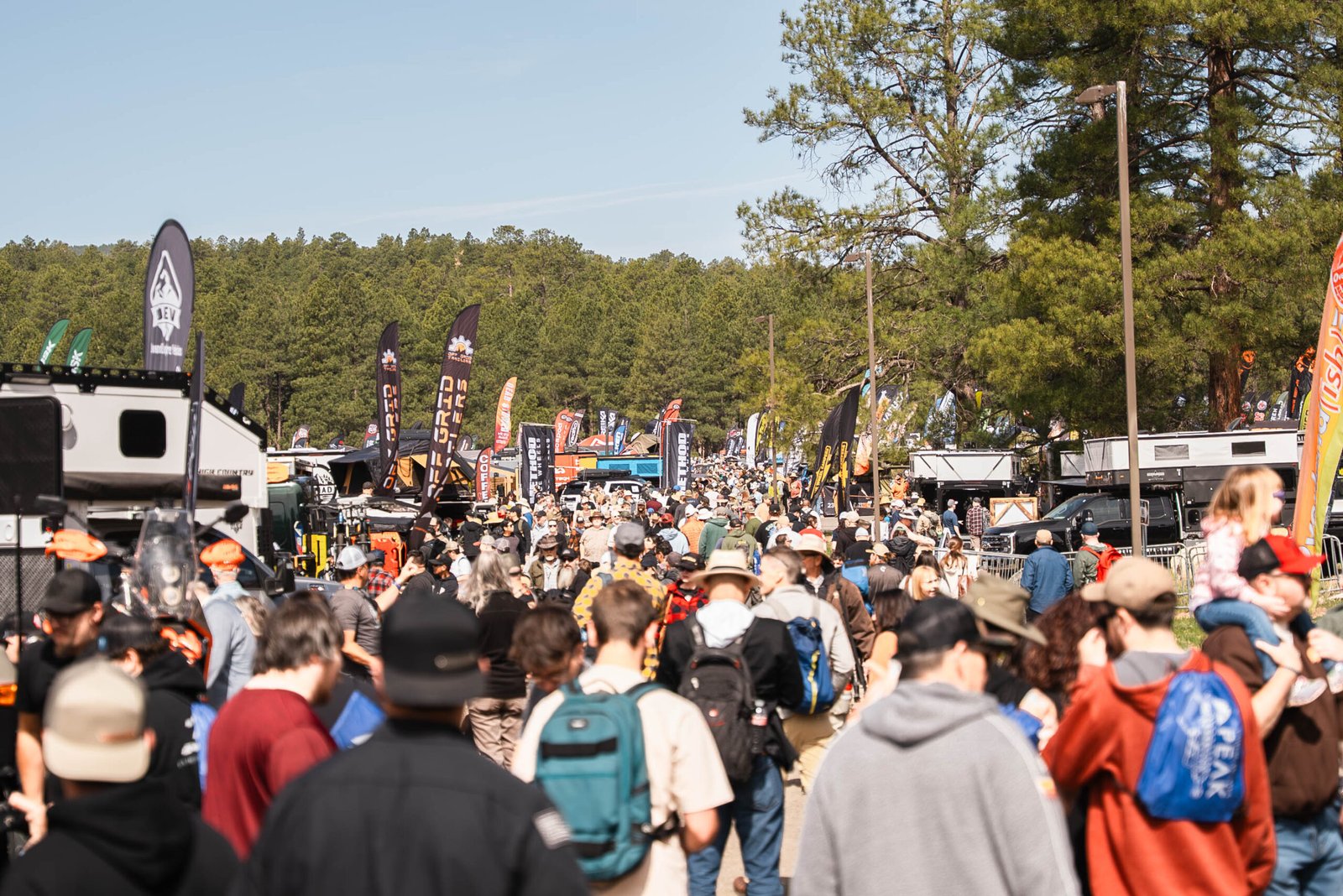 Crowds walking through vendor booths at Overland Expo West in Fort Tuthill